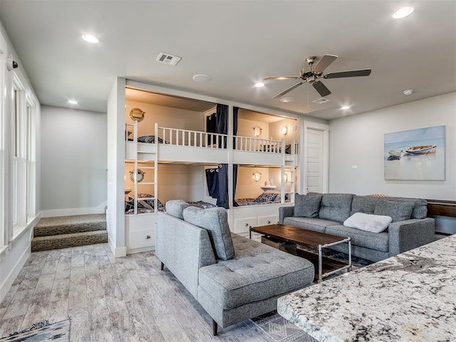 living room featuring light wood-type flooring and ceiling fan