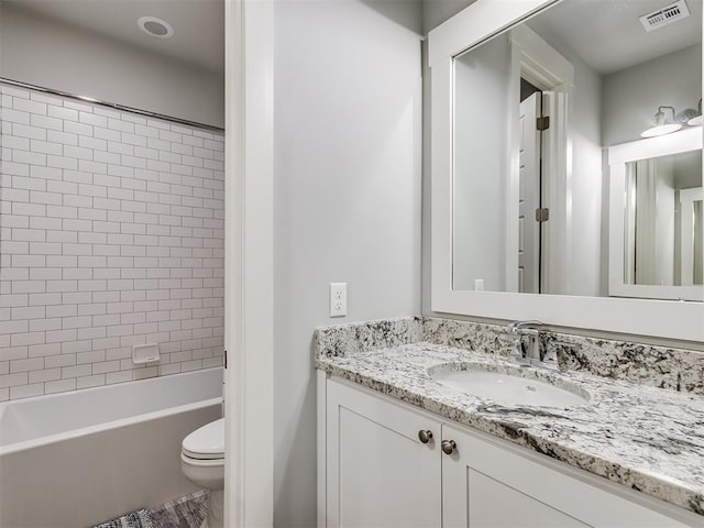 full bathroom with vanity, tiled shower / bath combo, and toilet