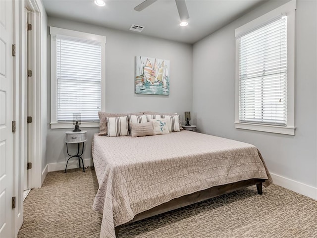 bedroom with multiple windows, ceiling fan, and carpet