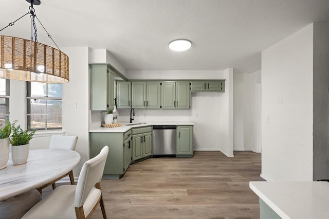 kitchen featuring stainless steel dishwasher, light hardwood / wood-style flooring, sink, and green cabinetry