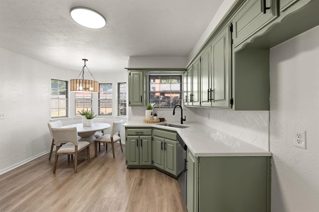 kitchen with dishwasher, light hardwood / wood-style floors, green cabinets, and sink