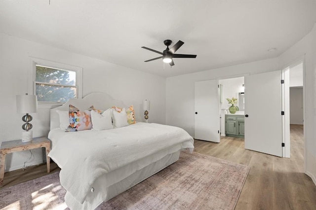 bedroom with ensuite bath, light hardwood / wood-style flooring, and ceiling fan