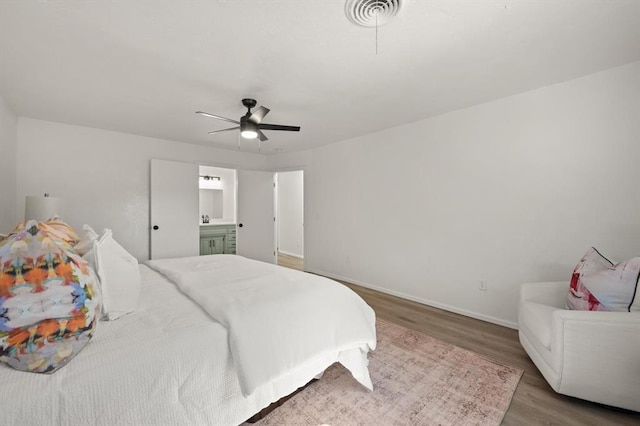 bedroom featuring hardwood / wood-style floors, ensuite bath, and ceiling fan