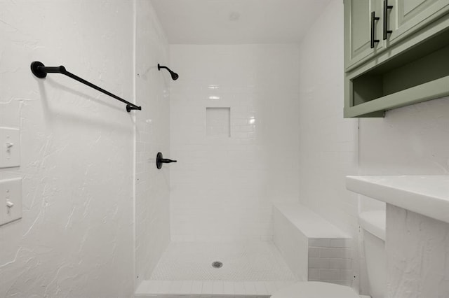 bathroom featuring toilet and tiled shower