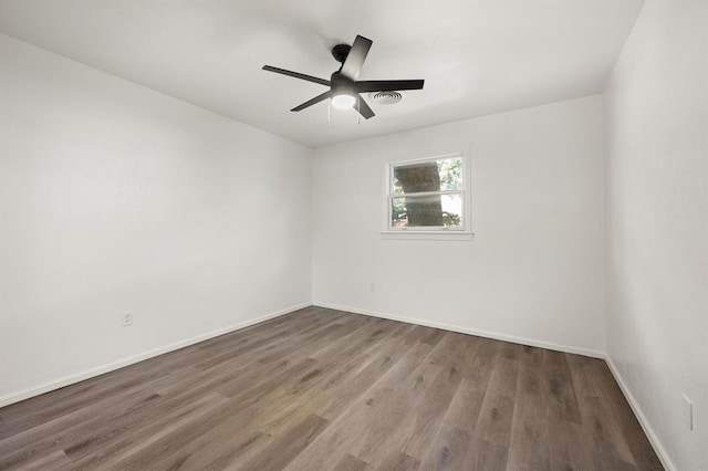 empty room with dark hardwood / wood-style floors and ceiling fan