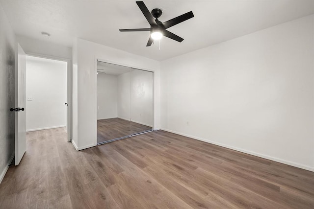 unfurnished bedroom with hardwood / wood-style floors, a closet, and ceiling fan