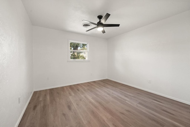 empty room featuring ceiling fan and hardwood / wood-style floors