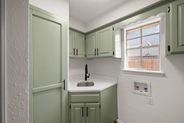 washroom with hookup for a washing machine, sink, and cabinets