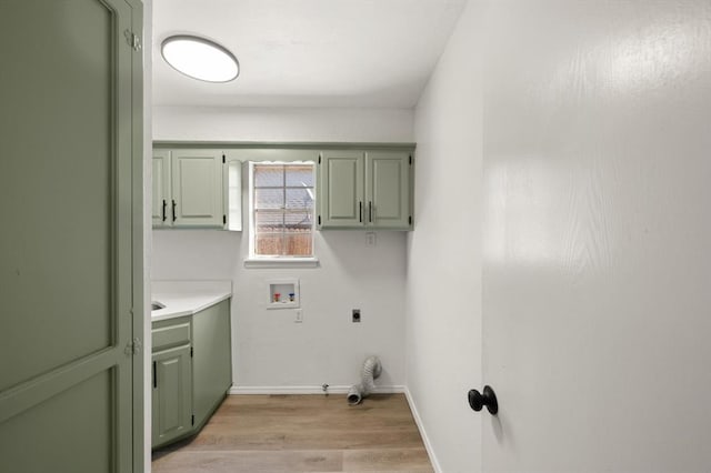 laundry area featuring cabinets, hookup for a washing machine, hookup for an electric dryer, gas dryer hookup, and light hardwood / wood-style floors