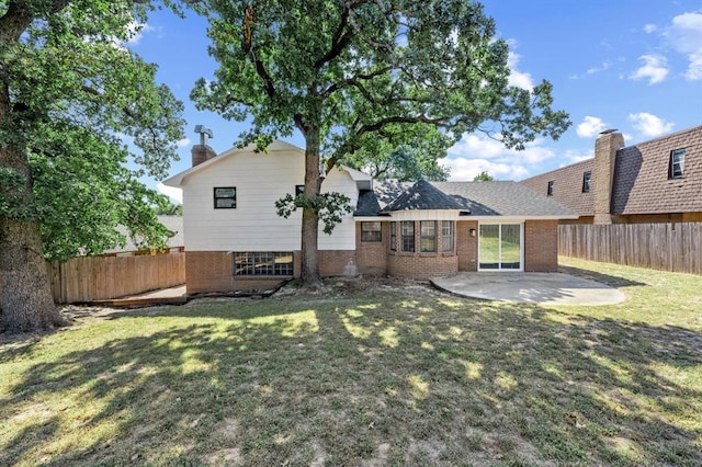 rear view of property with a patio and a lawn