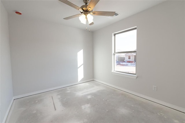 spare room featuring visible vents, ceiling fan, baseboards, and unfinished concrete floors