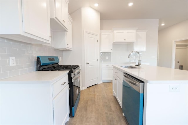 kitchen featuring stainless steel appliances, light wood-style flooring, a sink, and white cabinetry