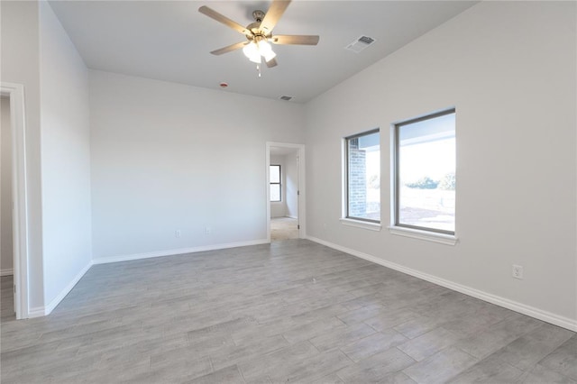 empty room featuring visible vents, ceiling fan, baseboards, and wood finished floors