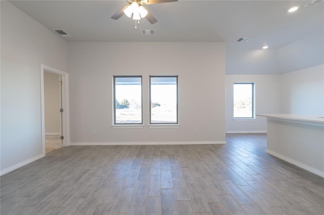 spare room featuring a ceiling fan, baseboards, visible vents, and wood finished floors