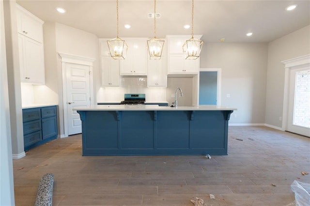 kitchen featuring stainless steel gas range, recessed lighting, white cabinetry, and light wood-style flooring