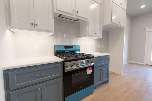 kitchen with stainless steel gas range, white cabinets, light countertops, and light wood finished floors