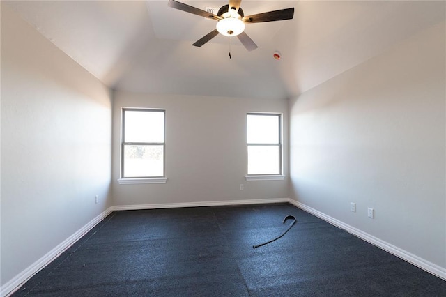 spare room with vaulted ceiling, plenty of natural light, and baseboards