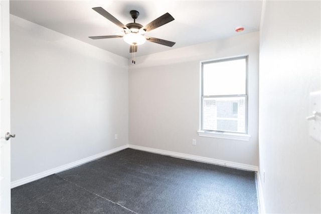 empty room featuring ceiling fan and baseboards