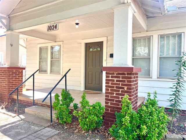 view of exterior entry featuring covered porch