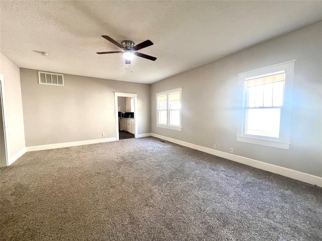 carpeted empty room featuring a textured ceiling and ceiling fan