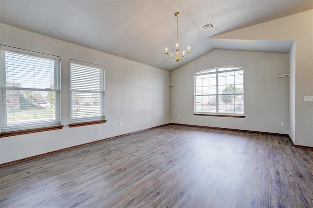 unfurnished room with hardwood / wood-style floors, lofted ceiling, and a notable chandelier