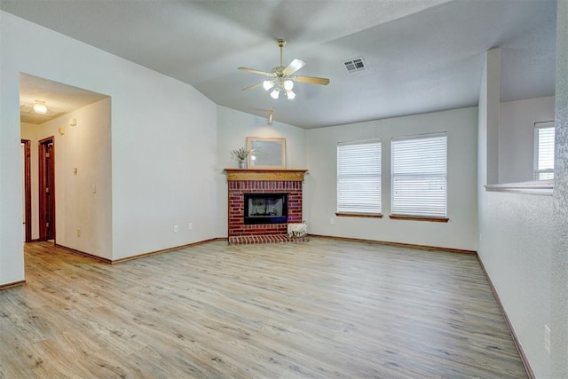 unfurnished living room featuring a fireplace, light hardwood / wood-style flooring, a wealth of natural light, and ceiling fan