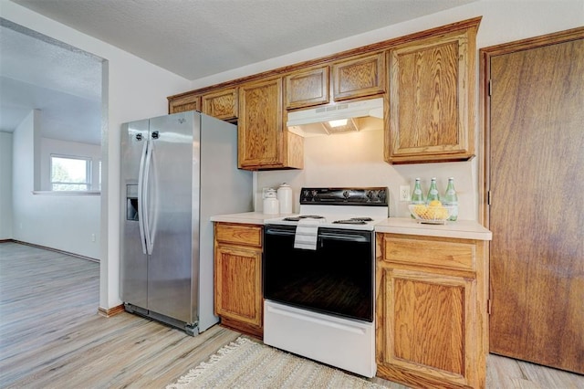 kitchen with stainless steel fridge, white electric range, a textured ceiling, and light hardwood / wood-style flooring