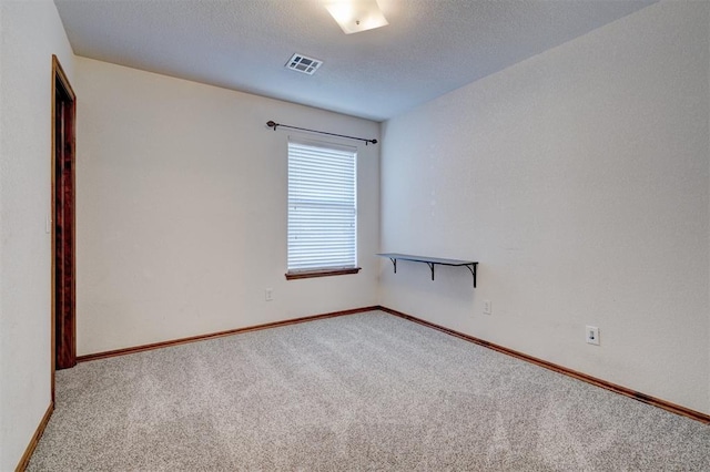 empty room with carpet floors and a textured ceiling