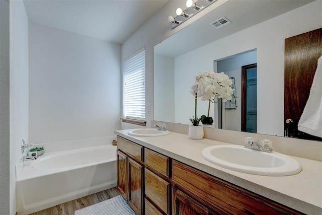 bathroom featuring a bathtub, vanity, and wood-type flooring