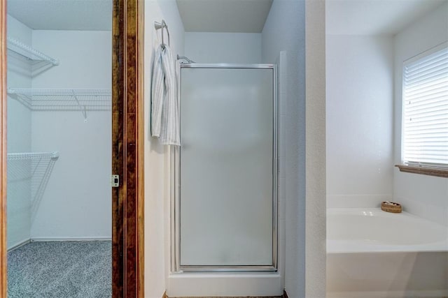 bathroom featuring shower with separate bathtub