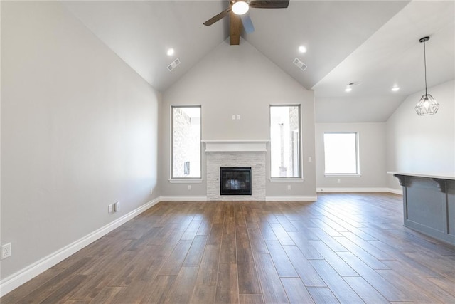 unfurnished living room featuring dark wood-style floors, beam ceiling, visible vents, ceiling fan, and a stone fireplace