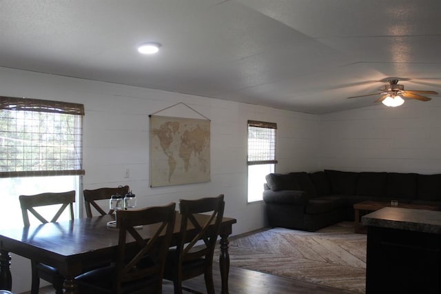 dining area with ceiling fan, vaulted ceiling, and hardwood / wood-style flooring