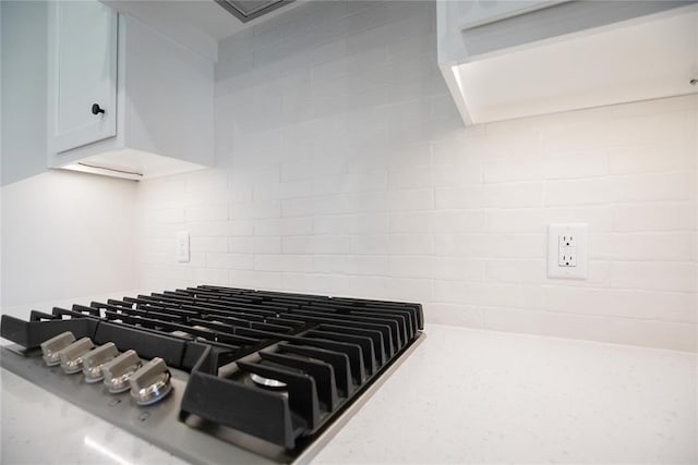 9312 Poppey Pl, Yukon, OK 73099 - kitchen view of backsplash, stainless steel gas stovetop, and white cabinets
