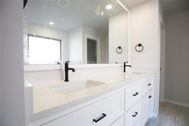 9312 Poppey Pl, Yukon, OK 73099 - bathroom with double vanity, marble look tiles, recessed lighting, and baseboards