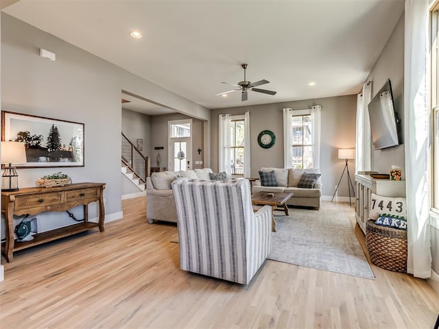 living room with ceiling fan and light hardwood / wood-style flooring