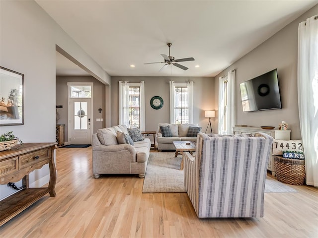 living room with light hardwood / wood-style flooring and ceiling fan