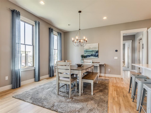 dining space with an inviting chandelier and light hardwood / wood-style flooring