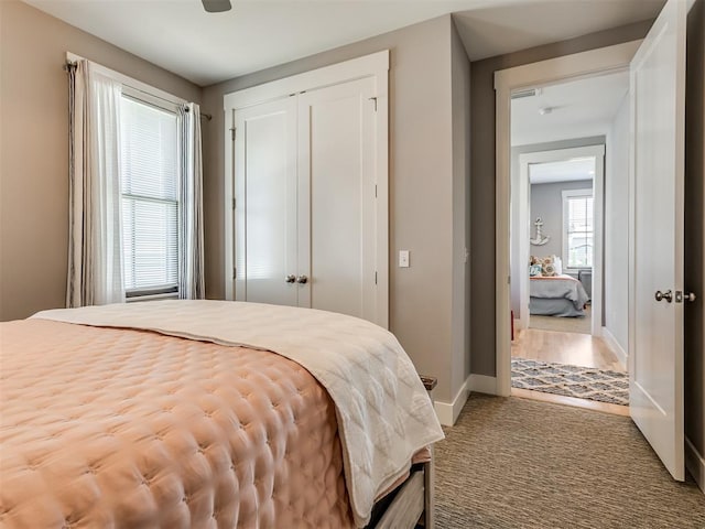 bedroom with hardwood / wood-style floors, ceiling fan, and a closet