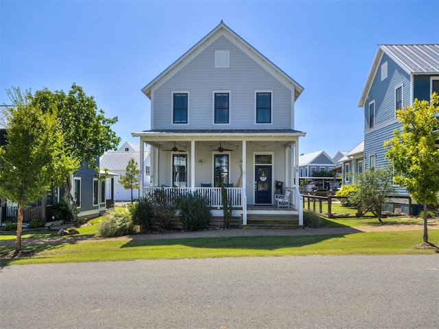 view of front of home featuring ceiling fan, covered porch, and a front yard