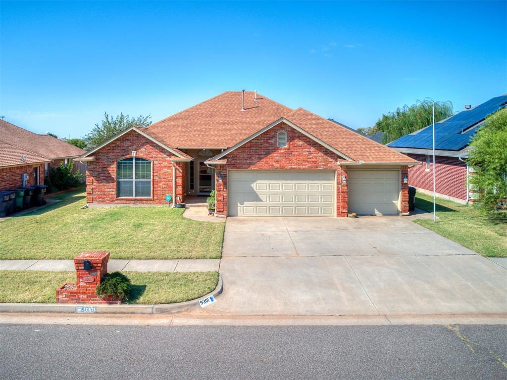 ranch-style house featuring a garage and a front yard