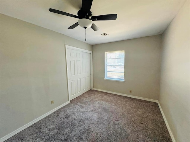 unfurnished bedroom with ceiling fan, a closet, and carpet