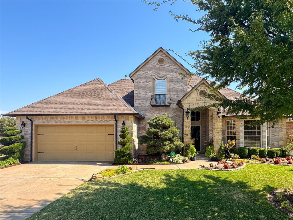 french country inspired facade featuring a garage and a front yard