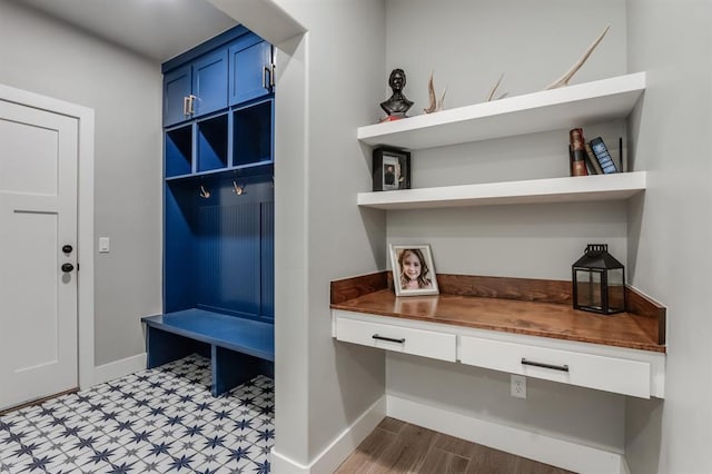 mudroom featuring built in desk and hardwood / wood-style flooring