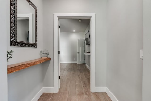 hallway with light hardwood / wood-style floors