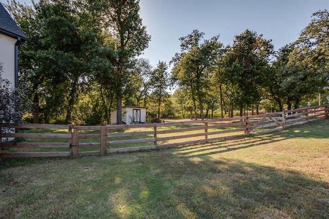 view of yard with a rural view and a storage shed