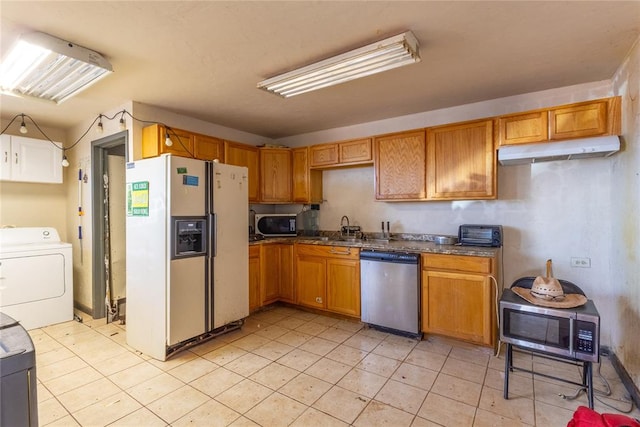 kitchen featuring sink, light tile patterned flooring, stainless steel appliances, and washer / dryer