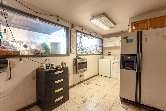 kitchen featuring white cabinets, heating unit, white refrigerator with ice dispenser, and washing machine and clothes dryer