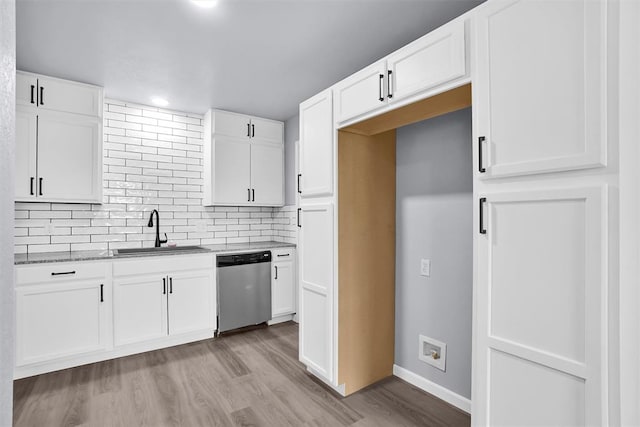 kitchen featuring backsplash, sink, stainless steel dishwasher, light wood-type flooring, and white cabinetry