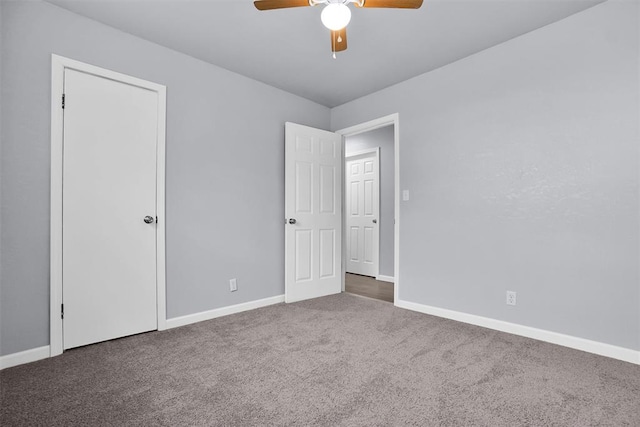 empty room featuring dark colored carpet and ceiling fan