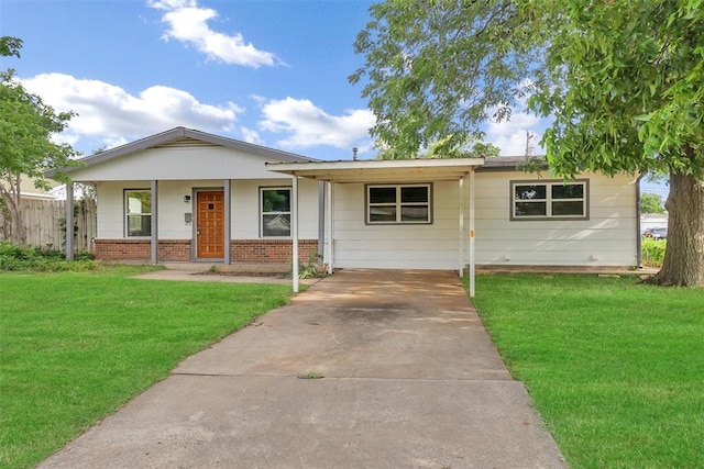 ranch-style house featuring concrete driveway, fence, a front yard, brick siding, and an attached carport